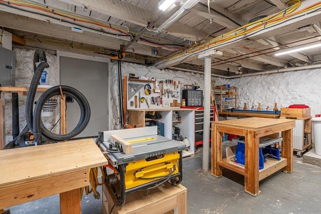 unfinished basement with a workshop area and electric panel