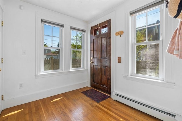 entryway with baseboards, a baseboard heating unit, and wood finished floors