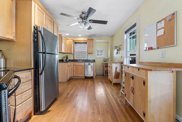 kitchen with a ceiling fan, light wood-type flooring, a sink, light brown cabinets, and stainless steel appliances