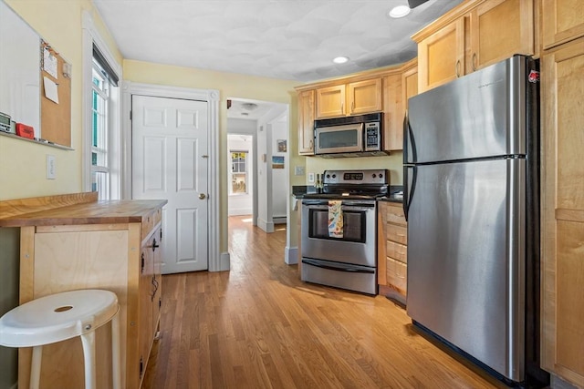 kitchen featuring light brown cabinetry, recessed lighting, appliances with stainless steel finishes, and light wood-style floors