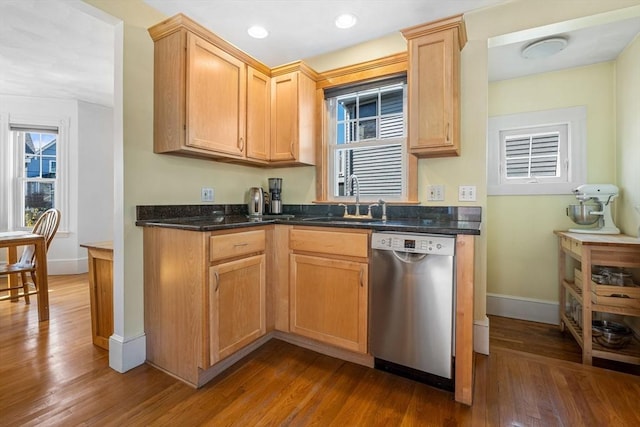 kitchen featuring dark wood-style flooring, dishwasher, a sink, baseboards, and recessed lighting