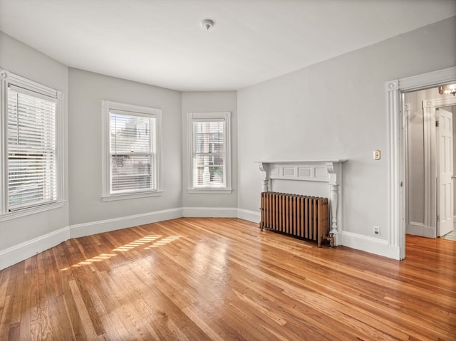 unfurnished living room with light hardwood / wood-style floors and radiator heating unit