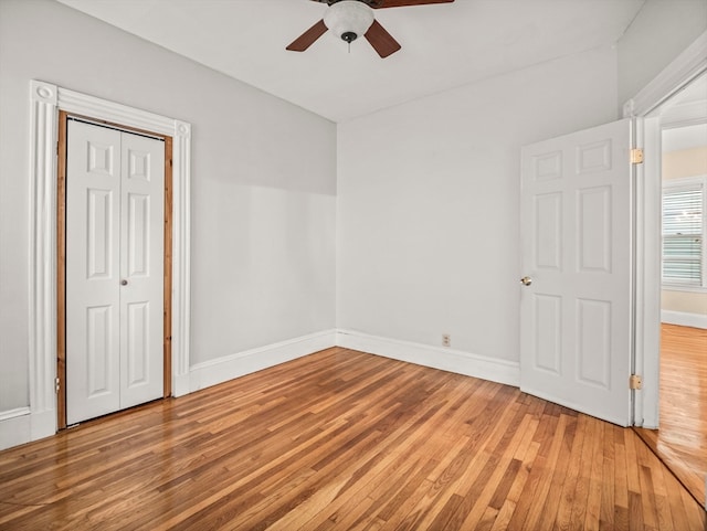 unfurnished bedroom with ceiling fan, a closet, and hardwood / wood-style flooring