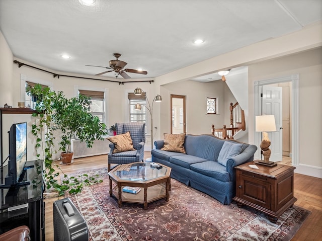 living room featuring light hardwood / wood-style flooring and ceiling fan