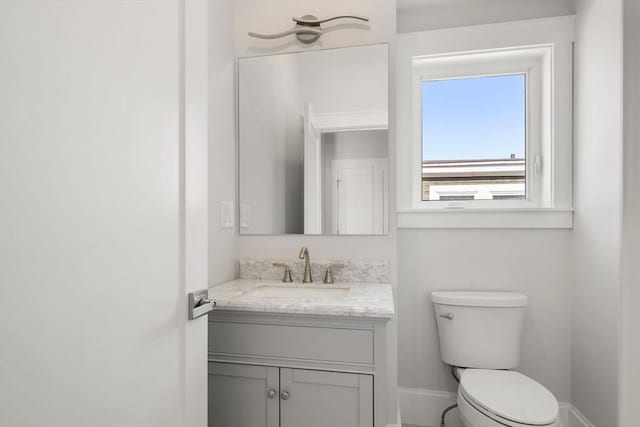 37-39 Governor Winthrop Rd, Somerville, MA 02145 - half bathroom featuring toilet, baseboards, and vanity