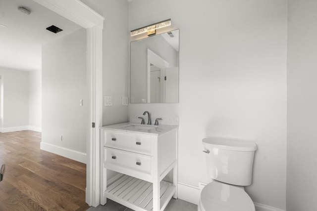 37-39 Governor Winthrop Rd, Somerville, MA 02145 - half bath featuring baseboards, vanity, toilet, and wood finished floors
