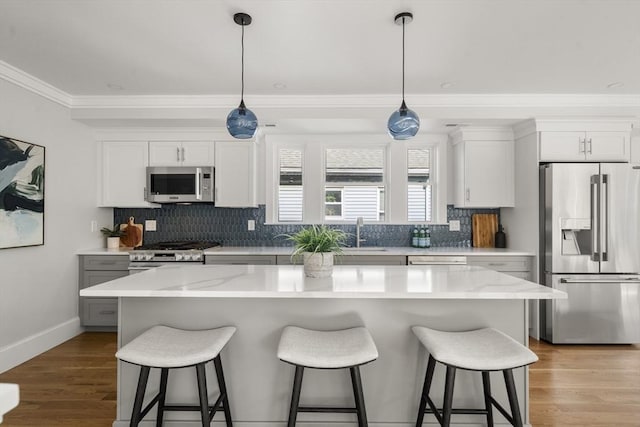 37-39 Governor Winthrop Rd, Somerville, MA 02145 - kitchen with crown molding, a sink, appliances with stainless steel finishes, and a kitchen bar