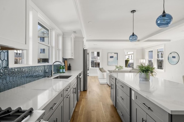 37-39 Governor Winthrop Rd, Somerville, MA 02145 - kitchen featuring wood finished floors, a sink, light stone counters, gray cabinetry, and open floor plan