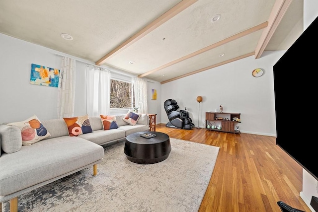 living area with lofted ceiling with beams, baseboards, and wood finished floors