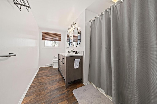 full bathroom with visible vents, baseboards, toilet, wood finished floors, and vanity