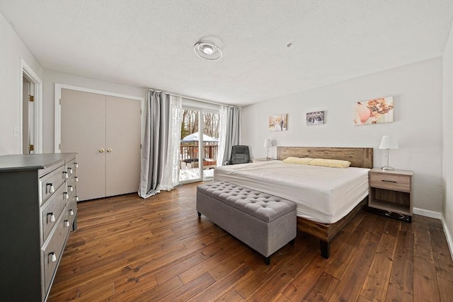 bedroom with access to exterior, baseboards, and dark wood-type flooring