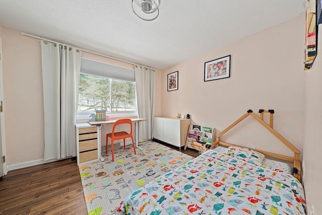 bedroom featuring baseboards and wood finished floors