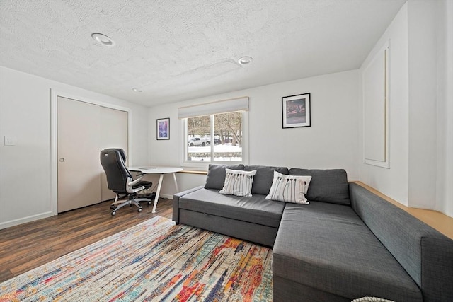 office with dark wood-style flooring, a textured ceiling, and baseboards