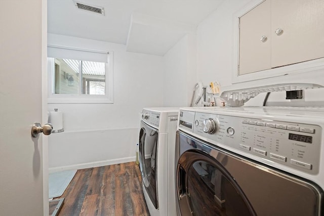 laundry area featuring washing machine and dryer, laundry area, dark wood-type flooring, visible vents, and baseboards