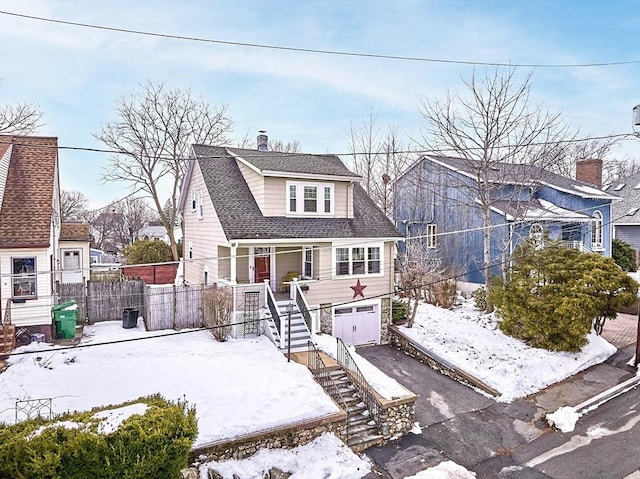 bungalow-style home with driveway, a garage, stairway, roof with shingles, and fence