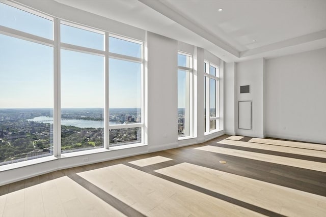 unfurnished room featuring wood-type flooring and a water view