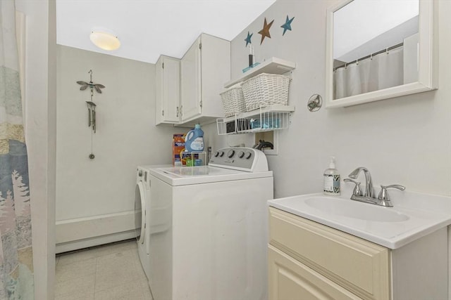 clothes washing area with cabinet space, light tile patterned floors, washing machine and dryer, and a sink