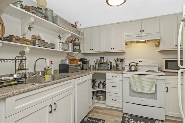 kitchen featuring light wood-style flooring, under cabinet range hood, open shelves, a sink, and white appliances