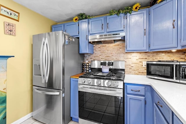 kitchen with backsplash, blue cabinetry, appliances with stainless steel finishes, light countertops, and under cabinet range hood