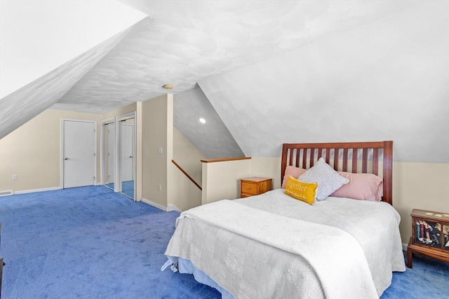 carpeted bedroom with baseboards, vaulted ceiling, and visible vents