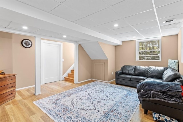 living area with visible vents, stairs, light wood finished floors, and a drop ceiling
