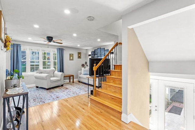 living room with ceiling fan, light wood finished floors, recessed lighting, baseboards, and stairway