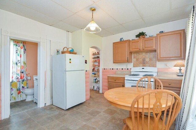 51 Garfield Ave, Revere, MA 02151 - kitchen with white appliances, a drop ceiling, light countertops, light brown cabinetry, and arched walkways