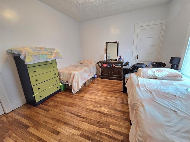 bedroom with wood-type flooring and a textured ceiling