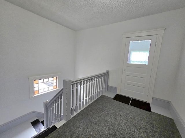 entryway featuring carpet floors and a textured ceiling