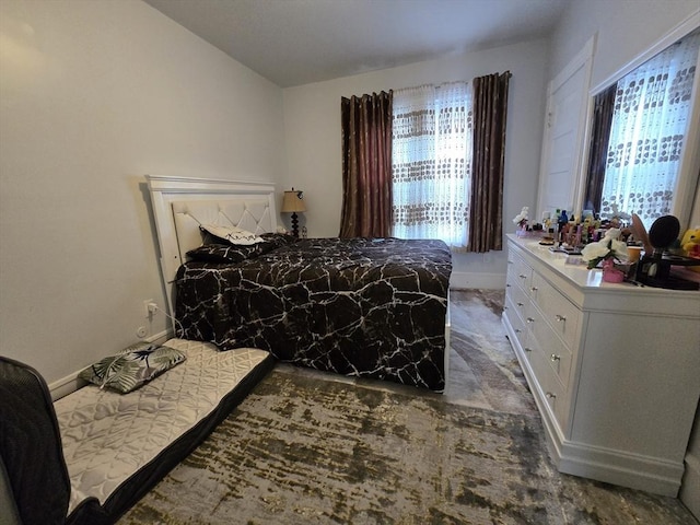 bedroom featuring multiple windows, baseboards, and lofted ceiling