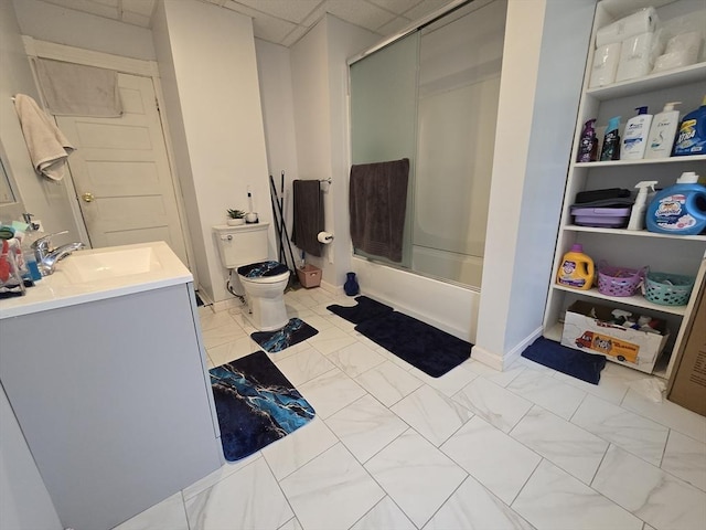 full bathroom featuring toilet, bath / shower combo with glass door, marble look tile flooring, and vanity