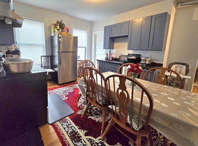 dining room with light wood-style floors and healthy amount of natural light