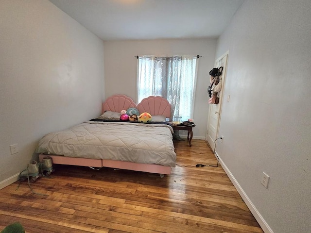 bedroom with hardwood / wood-style flooring and baseboards