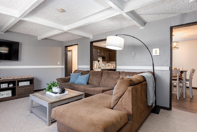 carpeted living room featuring coffered ceiling, beamed ceiling, and a textured ceiling