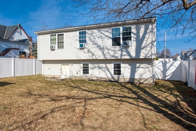 back of house with a lawn and a fenced backyard