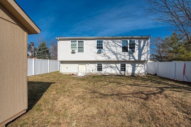 rear view of house with a yard and a fenced backyard