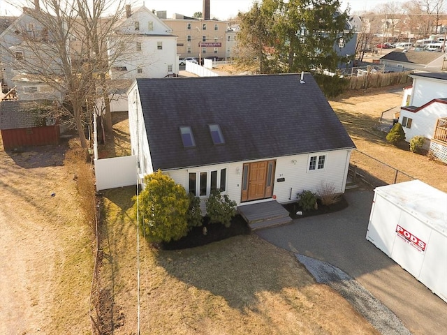 view of front facade with fence and a shingled roof