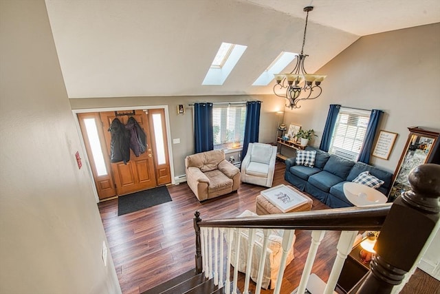 living area featuring dark wood finished floors, a chandelier, a skylight, and high vaulted ceiling