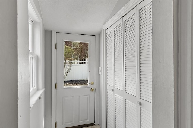 doorway to outside featuring a textured ceiling