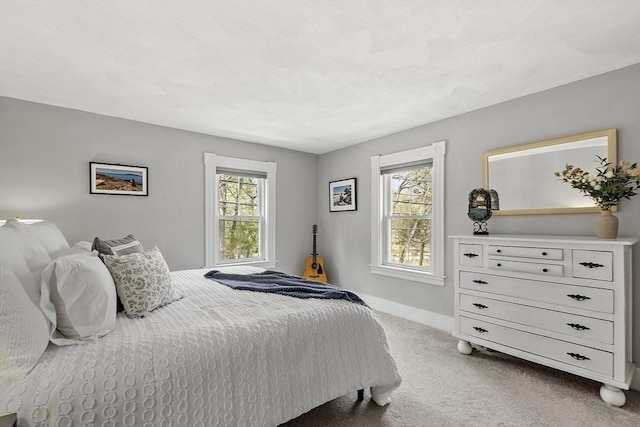 bedroom featuring light colored carpet and baseboards