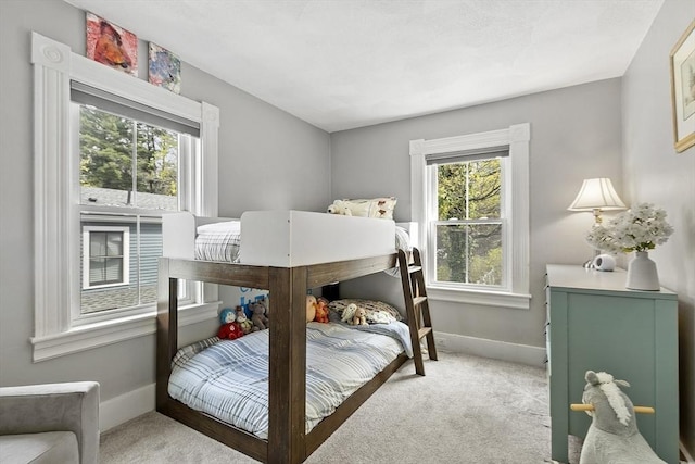 bedroom with baseboards and light carpet