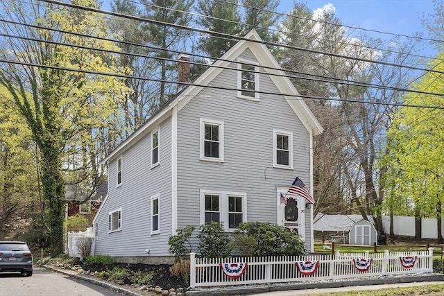view of front of property featuring a fenced front yard and a chimney