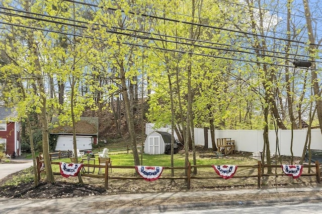 exterior space with a storage shed, fence, an outbuilding, and a garage