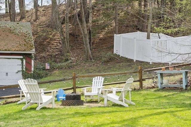 view of yard featuring an outdoor fire pit and fence