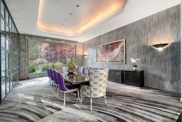 carpeted dining area featuring a raised ceiling