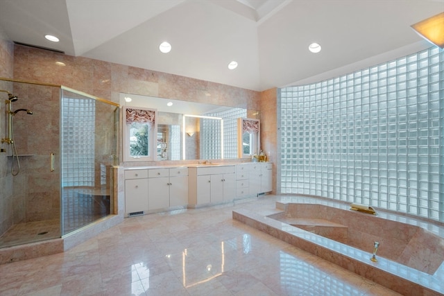 bathroom featuring vanity, tile walls, separate shower and tub, and vaulted ceiling