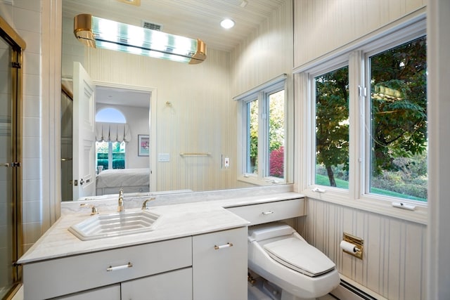 bathroom featuring toilet, baseboard heating, vanity, and plenty of natural light