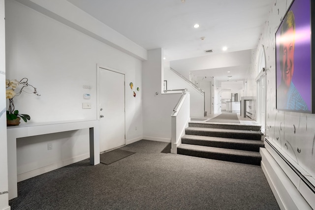 carpeted foyer entrance with a baseboard heating unit