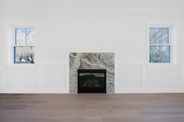 interior details with crown molding and a high end fireplace