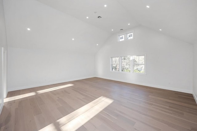 bonus room with light hardwood / wood-style floors and high vaulted ceiling